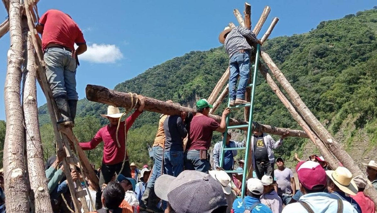 Cansados de esperar ayuda, habitantes de Texcatepec construyen puente colgante para poder cruzar el río