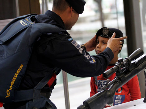 Un policía coloca una boina a un infante.