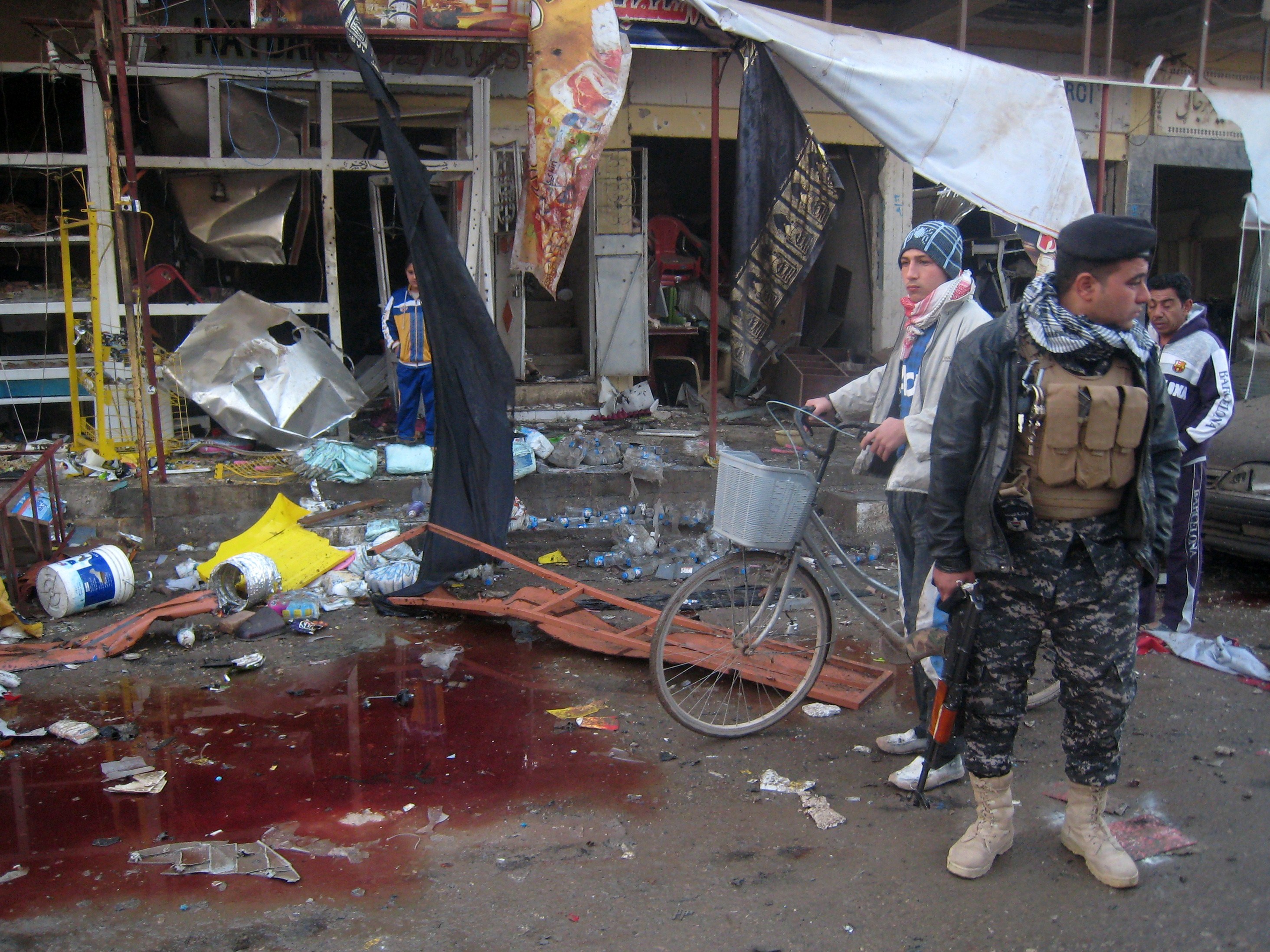 Un soldado iraquí hace guardia junto a un charco de sangre en el lugar de un atentado en Tuz Khurmatu, en el norte de Irak 