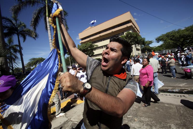 Un manifestante con una bandera grita consignas contra la reforma propuesta por Daniel Ortega en Managua
