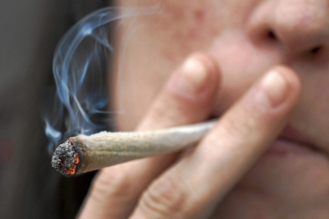 Una joven fuma un cigarrillo de mariguana