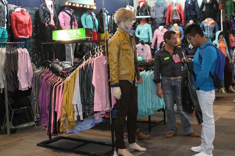 Comerciantes de ropa exponen sus productos con atractivos descuentos.