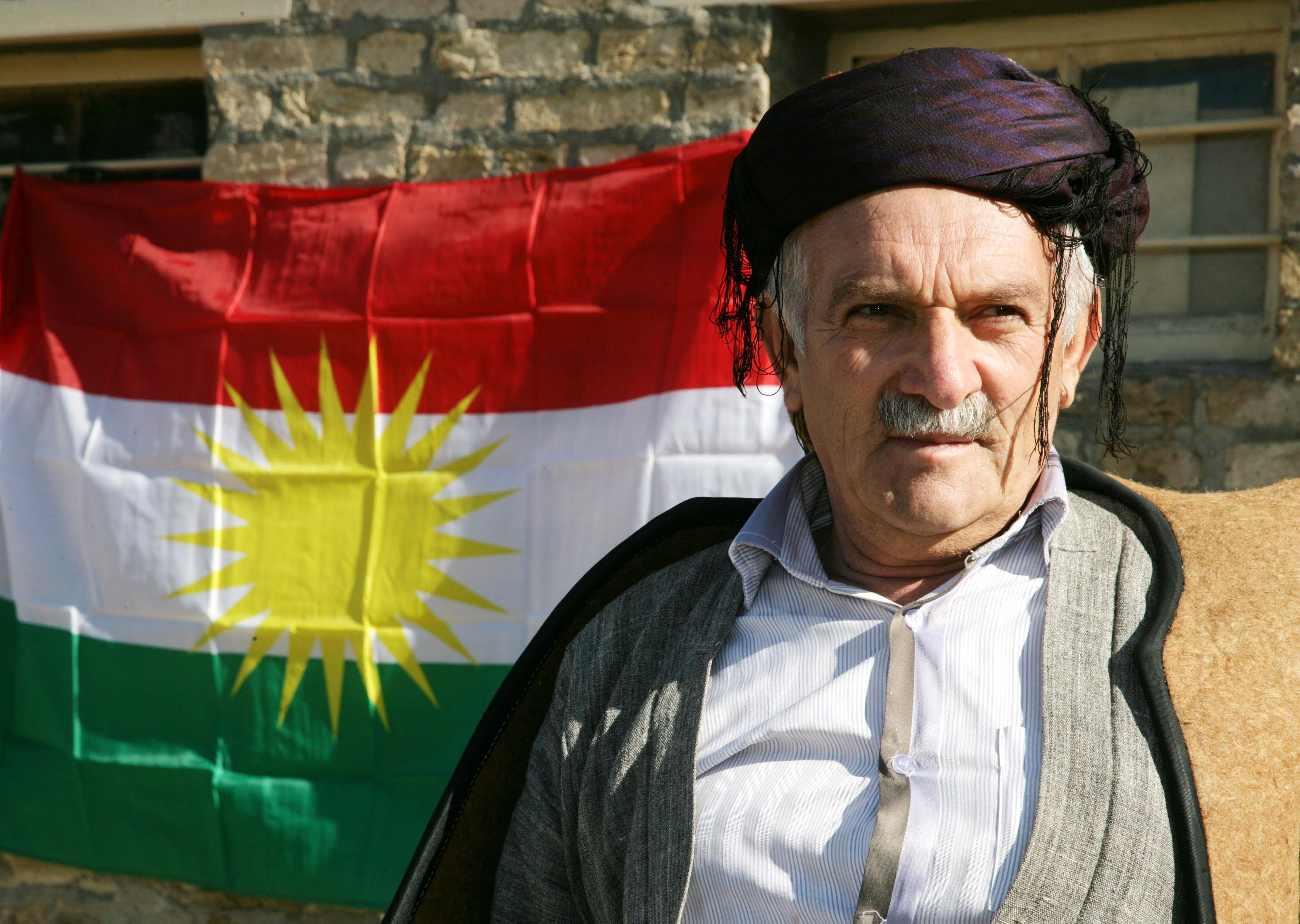 Un kurdo iraquí, junto a la bandera del Kurdistán, hoy en la celebración del Día de la Bandera en Arbil 