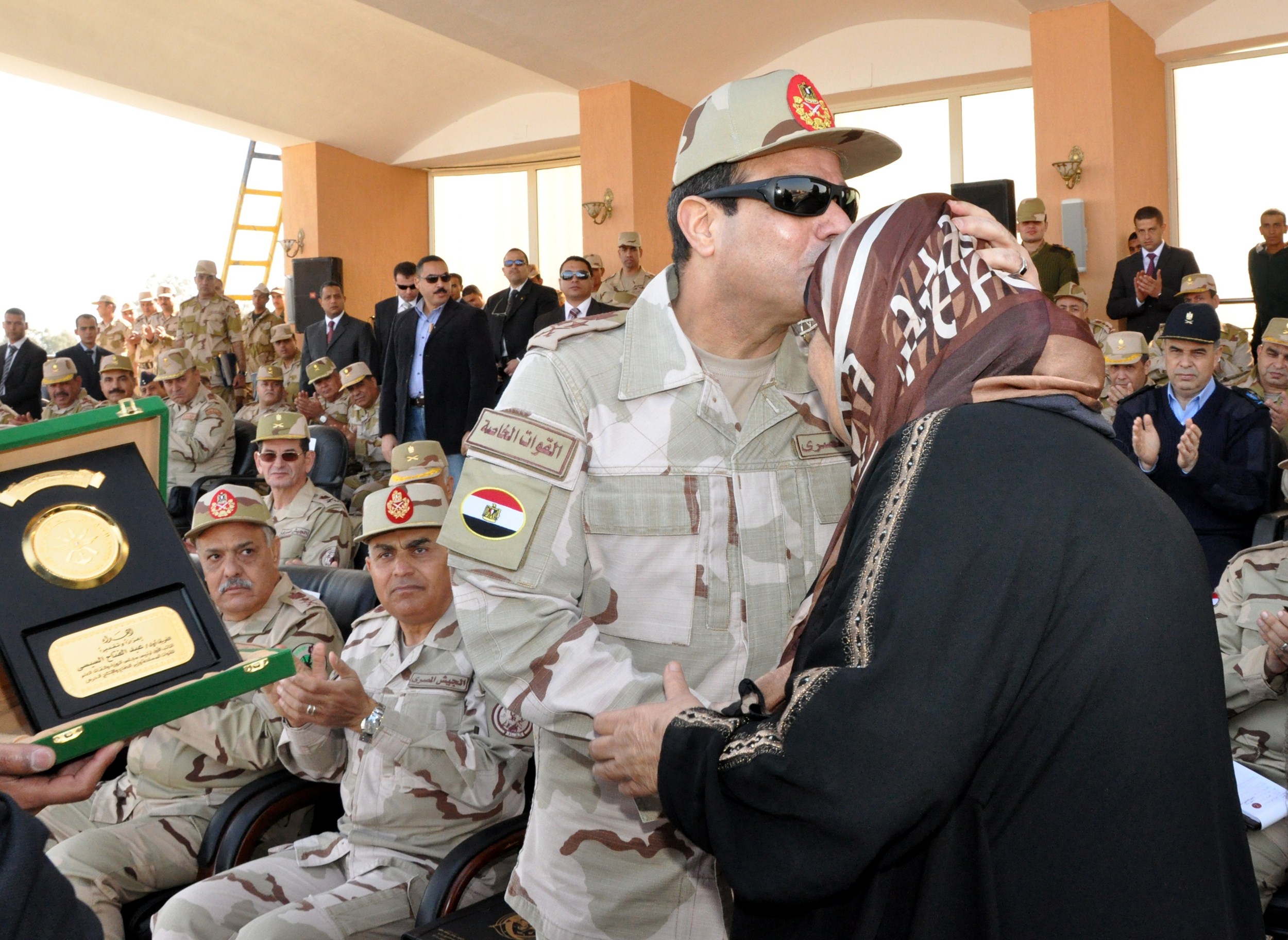El jefe del Ejército egipcio, Abdel Fattah al-Sisi, besa la cabeza de la madre de un soldado asesinado, en una ceremonia hoy en El Cairo