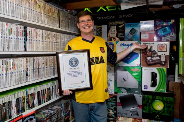 Michael Thomasson junto a su colección de videojuegos.