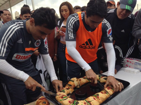 Omar Bravo y Aldo de Nigris partiendo la rosca para todos los presentes.