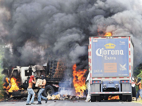 Dos de los camiones que fueron quemados en la jornada violenta de ayer en territorio michoacano. 