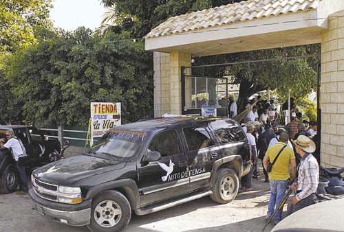 Civiles armados en torno a uno de los vehículos que utilizan para trasladarse por el poblado.