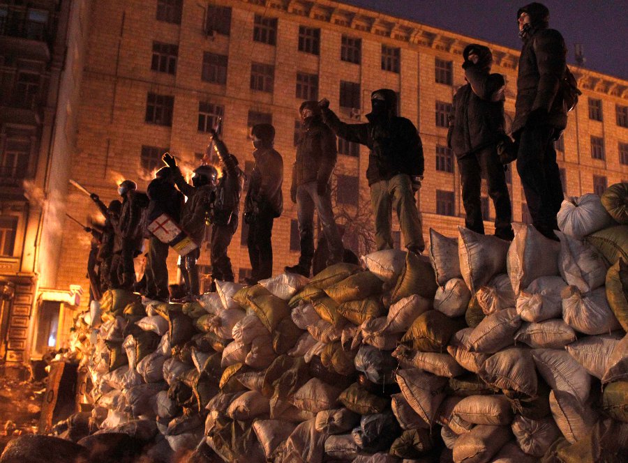 Los manifestantes antigubernamentales se colocan en una barricada durante una reunión en Kiev.