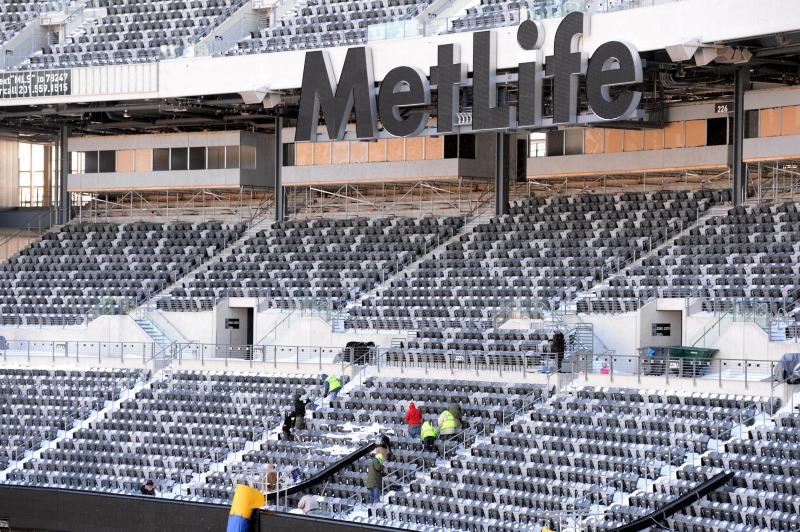 Vista general del estadio Metlife donde trabajadores quitan la nieve de los asientos.