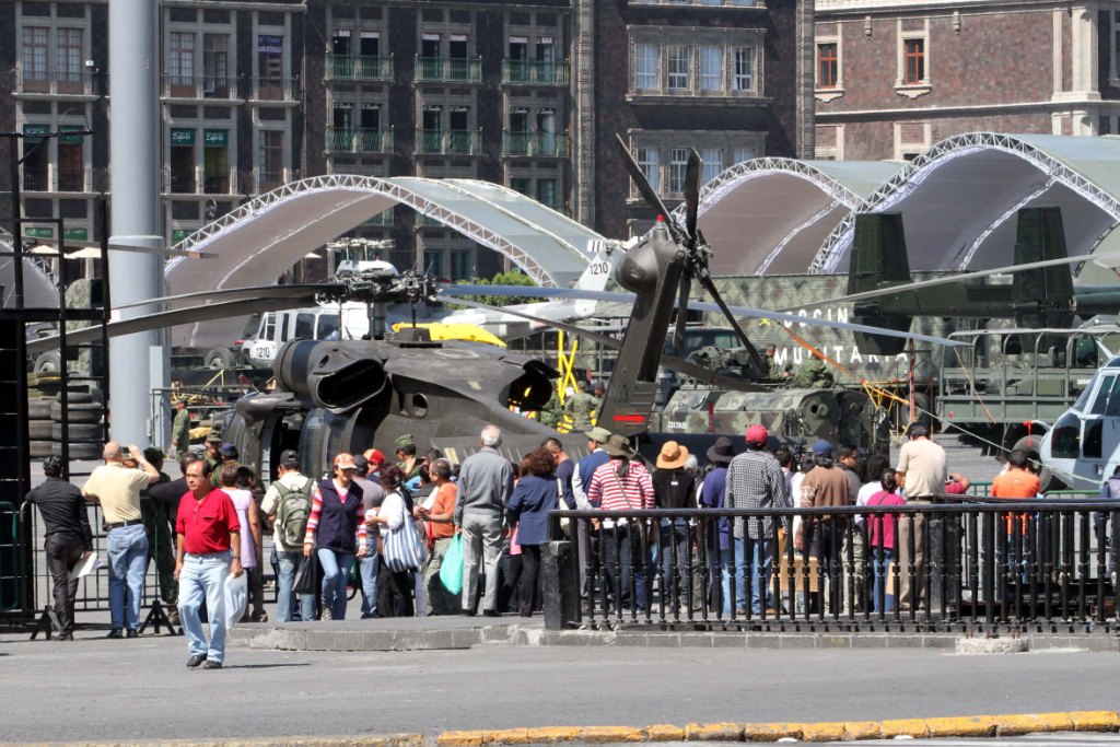 Capitalinos observan algunas de las aeronaves que forman parte de la exposión militar en el Zócalo.