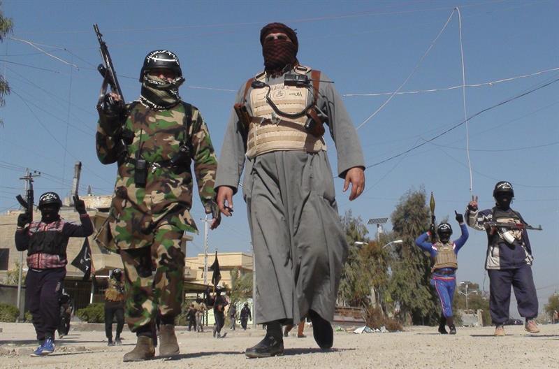 Varios hombres armados caminan por una calle de Faluya, al oeste de Irak