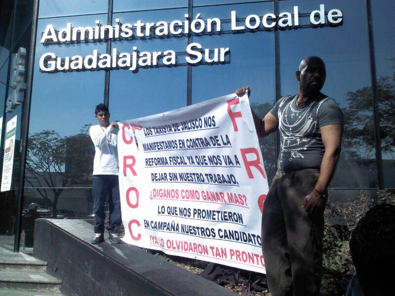 Taxistas integrantes del CROC se plantan con pancartas a las afueras del SAT.