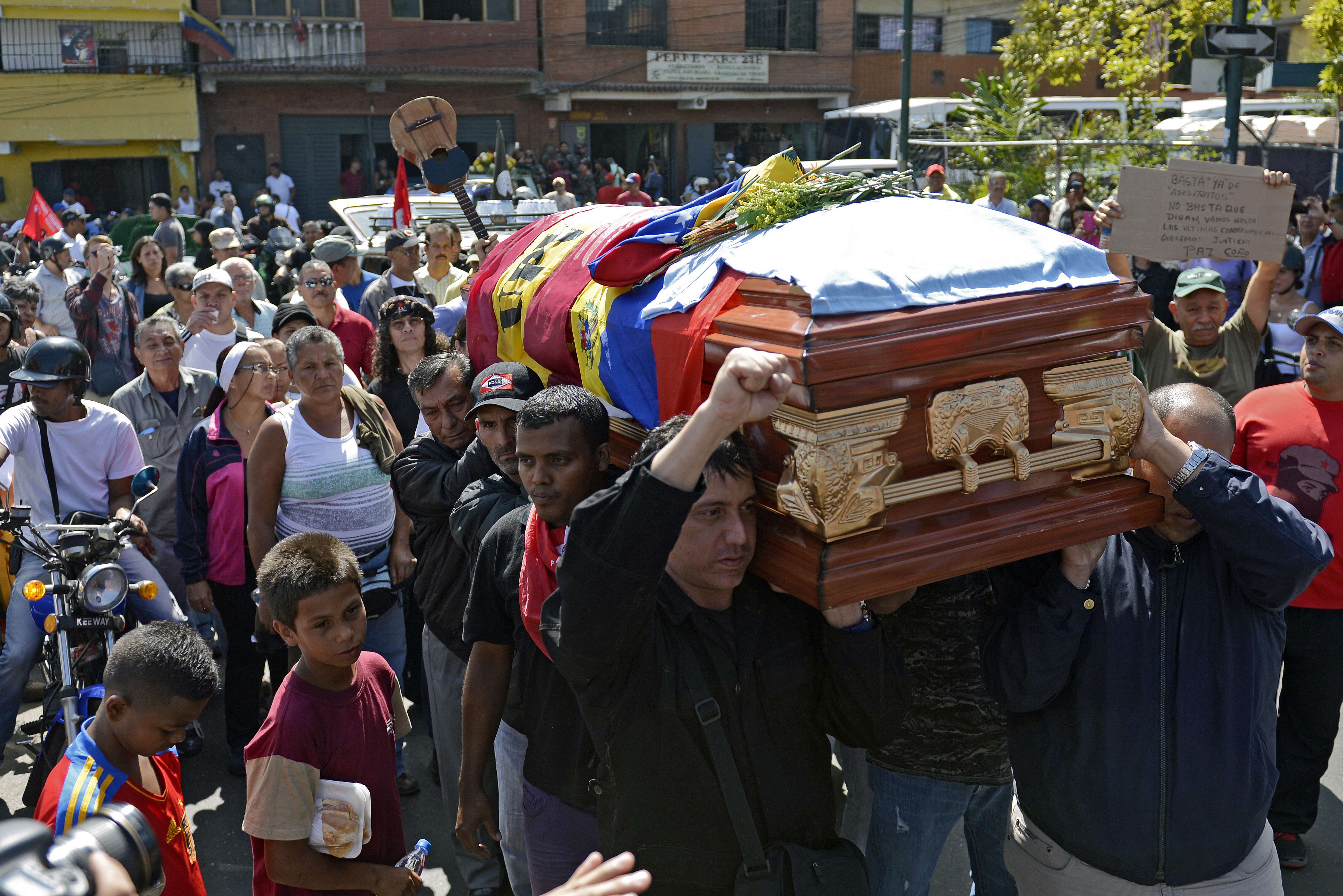 Familiares, amigos y simpatizantes oficialistas llevan el féretro de Juan Montoya, "Juancho", uno de los tres fallecidos en Caracas