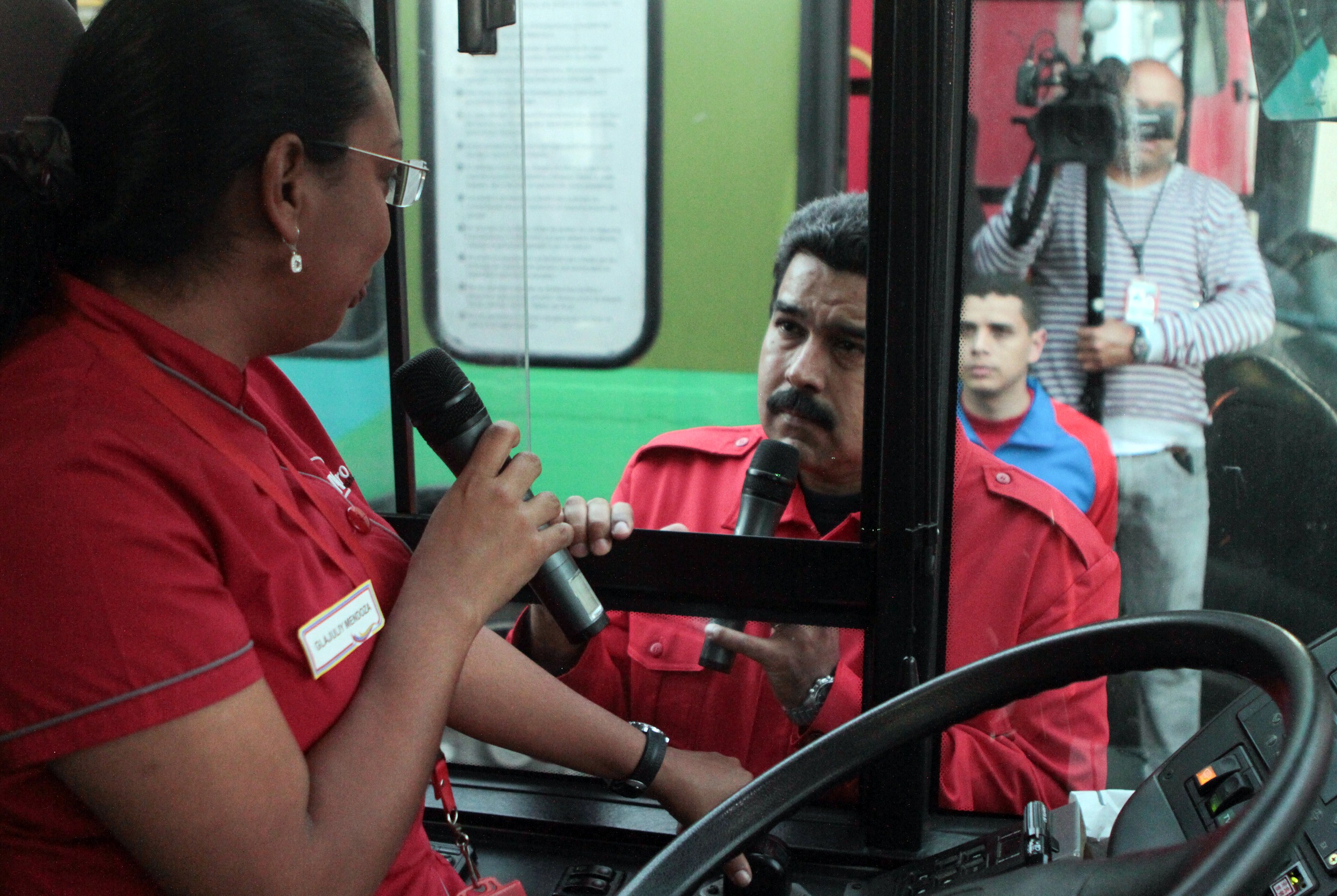 El presidente de Venezuela, Nicolás Maduro (c), habla con una conductora de autobús, cerca del palacio de Miraflores