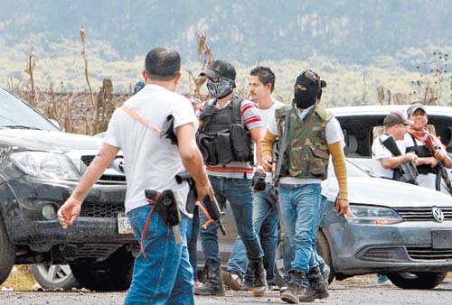 Integrantes de los grupos de la autodefensa de La Ruana vigilan una entrada al pueblo.