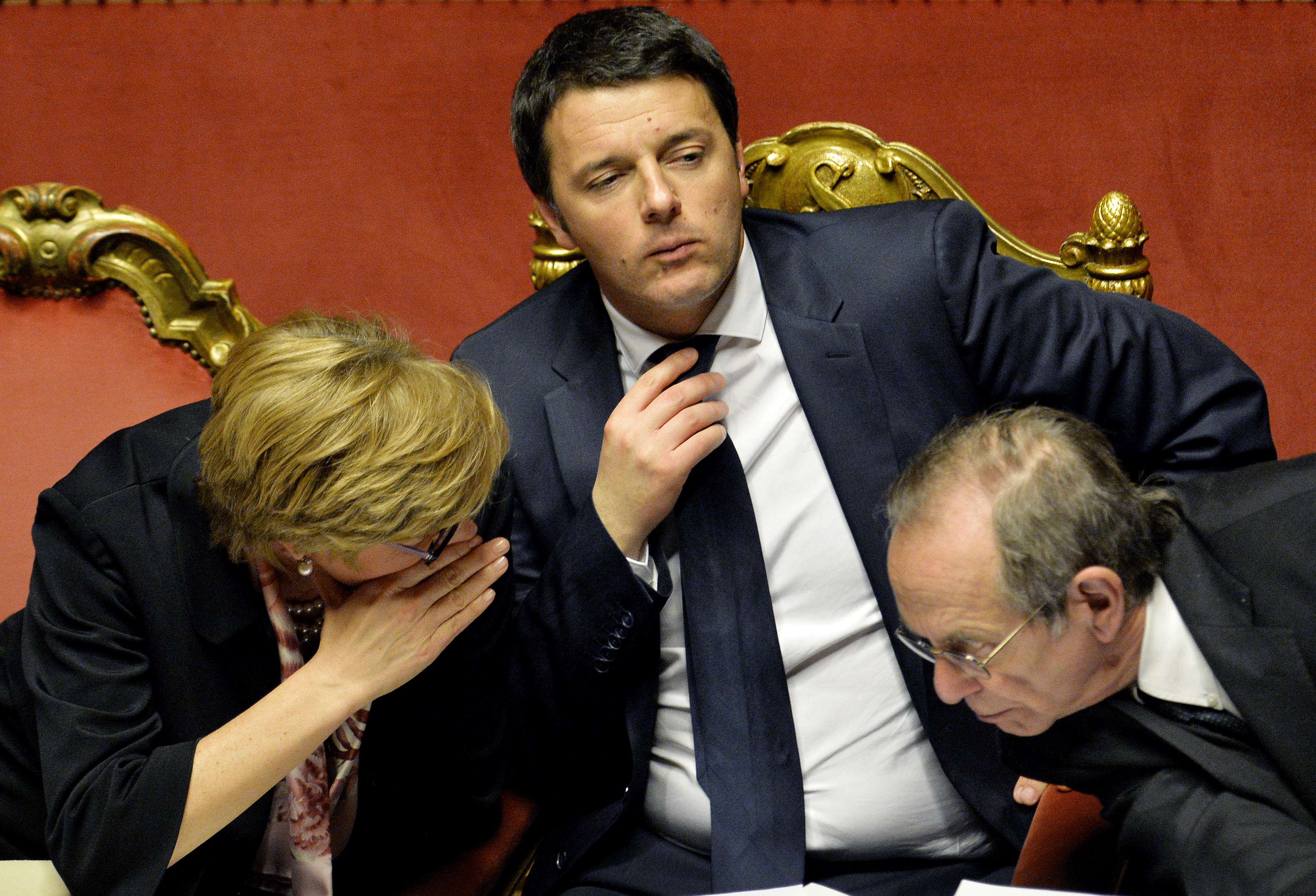 Renzi (c), en el Senado entre el ministro de Economía, Pier Carlo Padoan (d) y la ministra de Defensa, Roberta Pinotti