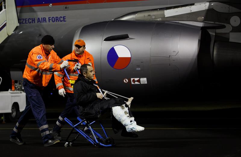 Un herido ucraniano es ayudado a descender de un avión militar checo a una ambulancia en la base aérea Kbely, en Praga 