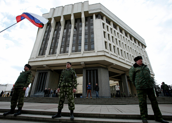 Miembros de las unidades de auto defensa de Crimea resguardan el edificio del Parlamento de Crimea en Simferópol.