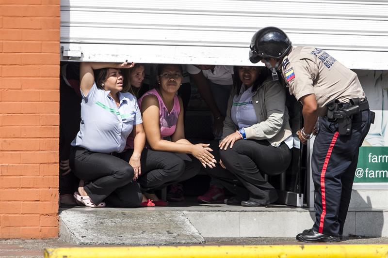 Mujeres se resguardan en un local comercial mientras agentes custodian las inmediaciones de la Av. Francisco de Miranda 