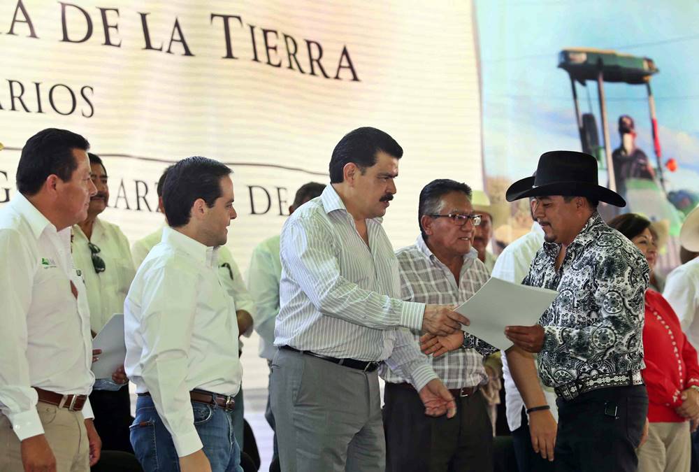 Entrega simbólica de títulos de propiedad.