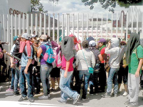 Alumnos encapuchados entran a la sede del instituto. 