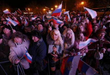 Una mujer sostiene el retrato de Vladimir Putin en medio de los festejos por la reincorporación de Crimea a territorio ruso