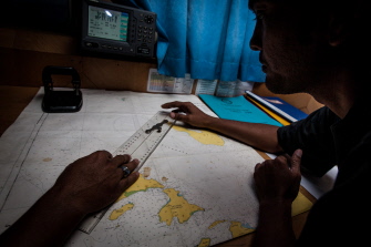 Una funcionaria del Servicio Nacional de Rescate indonesio estudia el mapa durante la búsqueda del avión desaparecido en el mar de Andamán