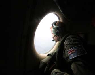 Un tripulante de un avión AP-3C Orion de la Royal Australian Air Force  observa el Océano ïndico en las tareas de busqueda del avión