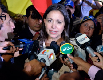 María Corina Machado (c) habla con los medios durante el seminario sobre la democracia en Lima