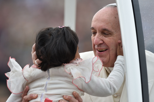 El papa Francisco besa a una niña durante la audiencia general en la plaza de San Pedro. 