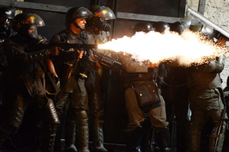 Miembros de la Guardia Nacional lanzan gas lacrimógeno a los manifestantes en una calle de Caracas