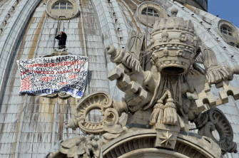Marcello di Finizio, en la cúpula de San Pedro junto a la pancarta de protesta desplegada