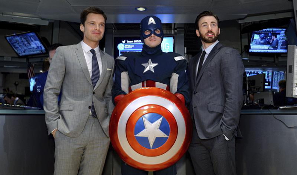 Los actores Sebastian Stan y Chris Evans posan junto a un hombre vestido de Capitán América.