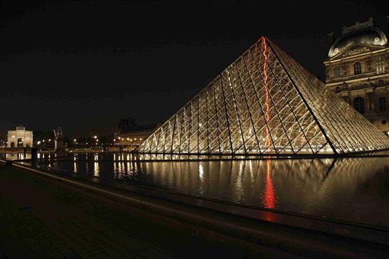 Fotografía facilitada por el Museo Louvre que muestra la pirámide acristalada y el rayo de neón inaugurado hoy por Claude Lévêque (1953), uno de los a