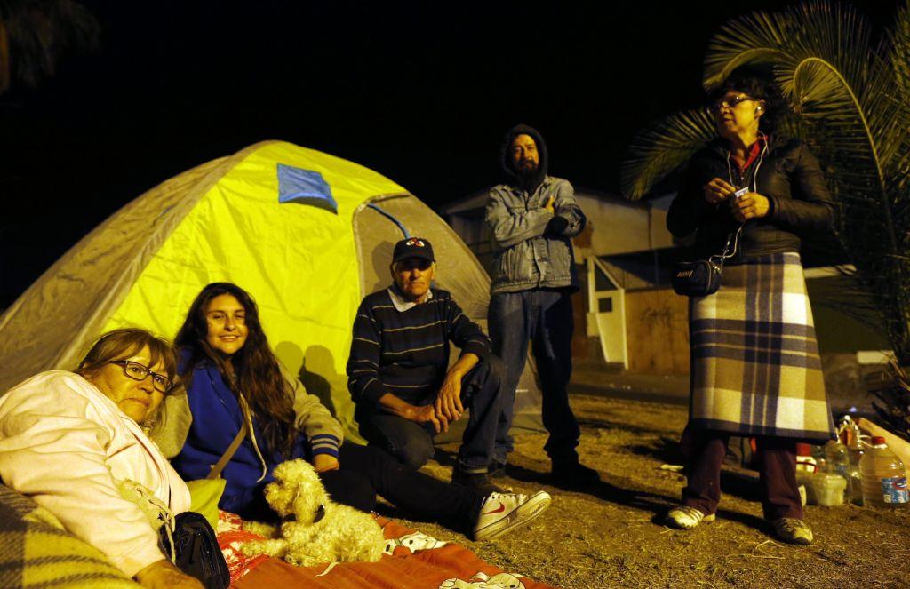 Una familia se prepara para pasar la noche al aire libre en una tienda de campaña en un parque de Iquique luego del terremoto de 8.2 grados.