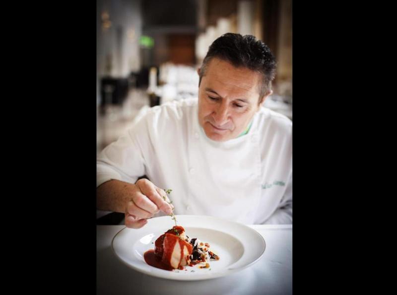 Un chef muestra el gallo de corral con achicote acompañado de arroz, plato basado en la gastronomía de México como homenaje a la escritora y periodist