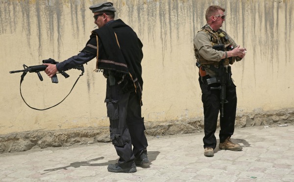 Guardias de seguridad extranjeros resguardan la puerta principal del Hospital Internacional Cure en Kabul, Afganistán, donde fueron asesinados tres mé