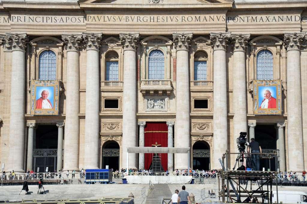 Los tapices que muestran la imagen de los Papas Juan Pablo II  y Juan XXIII se ven en los balcones de la basílica de San Pedro.