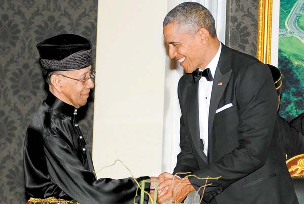 Barack Obama estrecha las manos del rey malasio Abdul Halim.