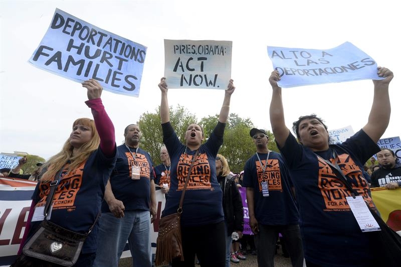 Pancartas que dicen "Las deportaciones hacen daño a las familias", "Presidente Obama actúa ahora" y "Alto a las deportaciones" 