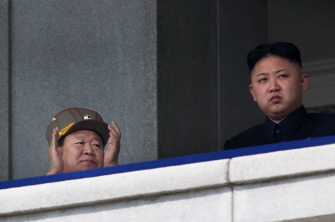 Un alto cargo norcoreano (i), que se cree que es  Choe Ryong-Hae (i), con el líder norcoreano Kim Jong-Un (d), en un desfile militar el 15 de abril de