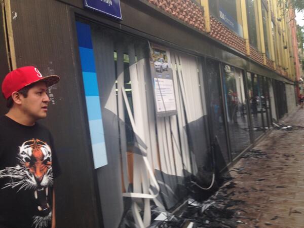 Los jóvenes encapuchados rompieron los vidrios de una sucursal bancaria.