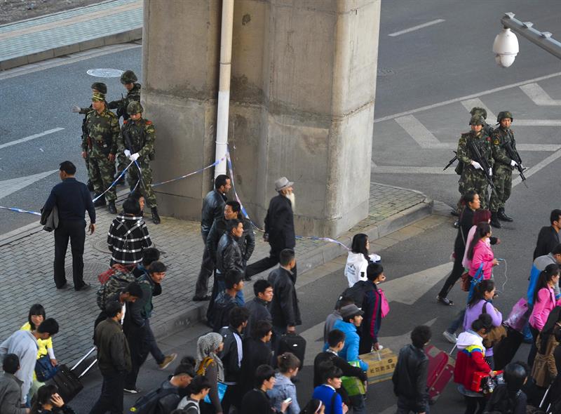 Policías paramilitares chinos permanecen en estado de alerta en el exterior de la estación sur de ferrocarril de Urumqi, después del atentado