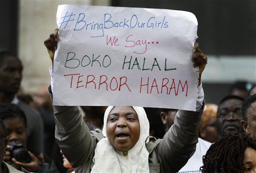 Los manifestantes sostienen pancartas que protestan sobre el secuestro de las niñas en Nigeria