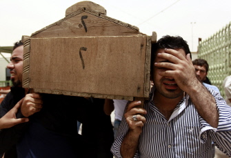Varios hombres llevan el ataúd de un peregrino chiita asesinado en un ataque suicida en el barrio de Mansur en Bagdad, en su funeral en Najaf