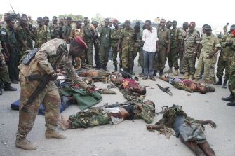 Un oficial somalí fotografía uno de los soldados muertos en la escena del ataque de los insurgentes islamistas en Mogadiscio