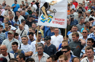 Mineros del carbón muestran una pancarta que dice "El fascismo no pasará" al manifiestarse contra la ofensiva ucraniana en Donetsk 