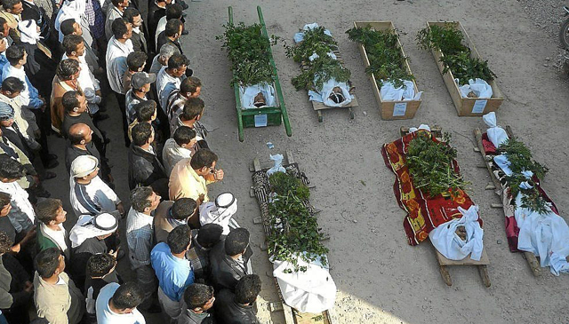 Sirios rezan ante los cuerpos de fallecidos en la represión en la ciudad de Hula