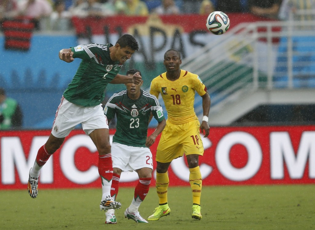 Los mexicanos Francisco Rodríguez y José Juan Vázquez se disputan el balón con el camerunés Enoh Eyong.